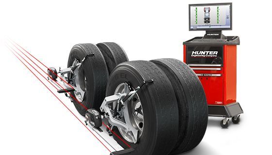 A stack of tires are being aligned by a machine.