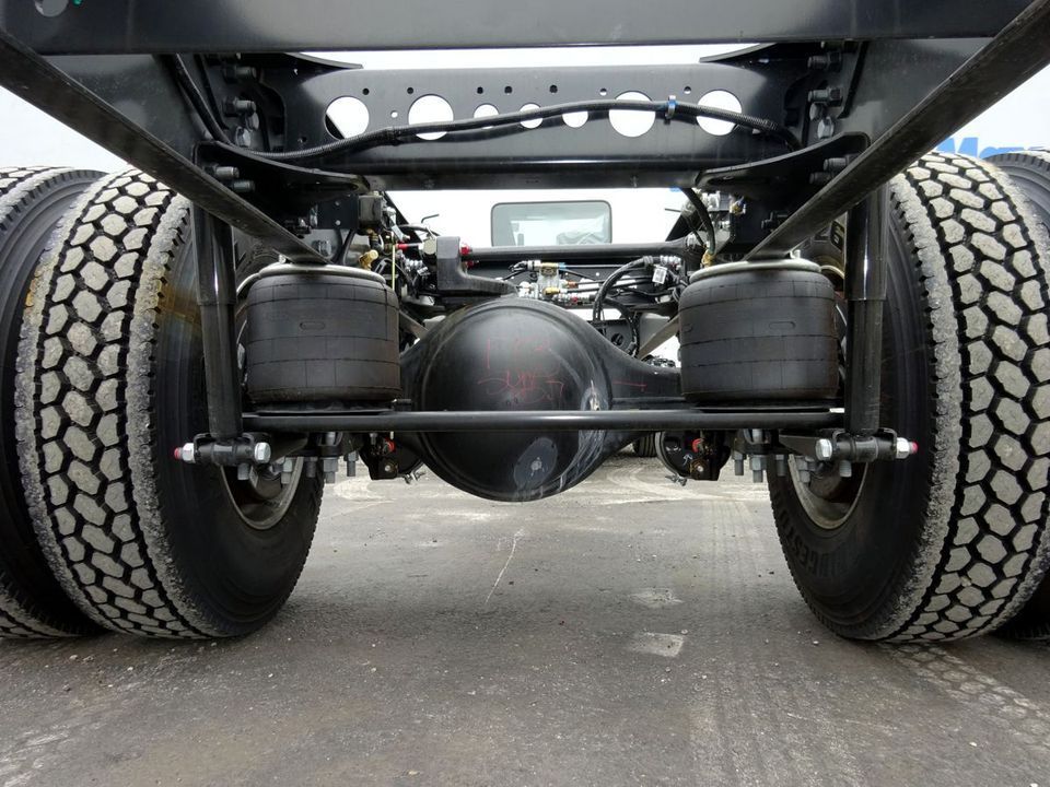 The rear axle of a semi truck is shown from underneath.
