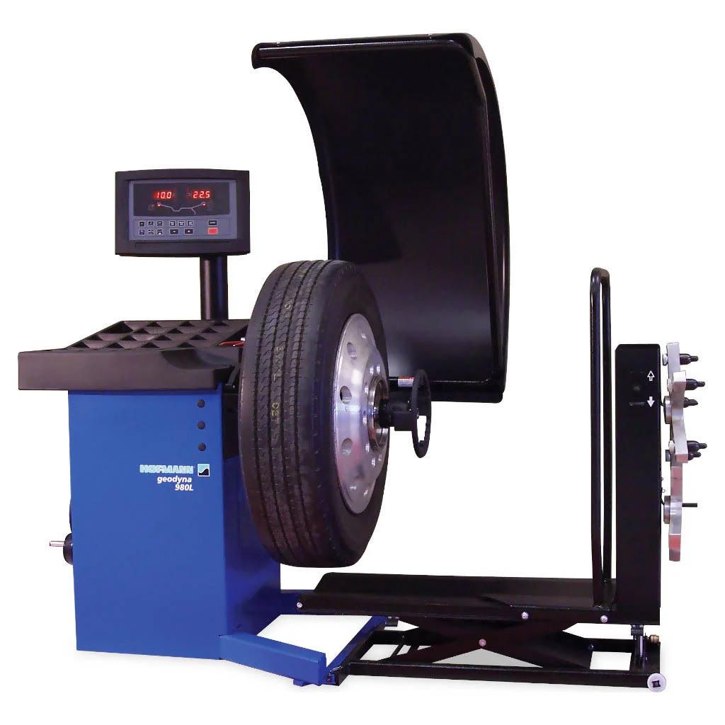 A blue wheel balancer with a tire on it and a digital display above it