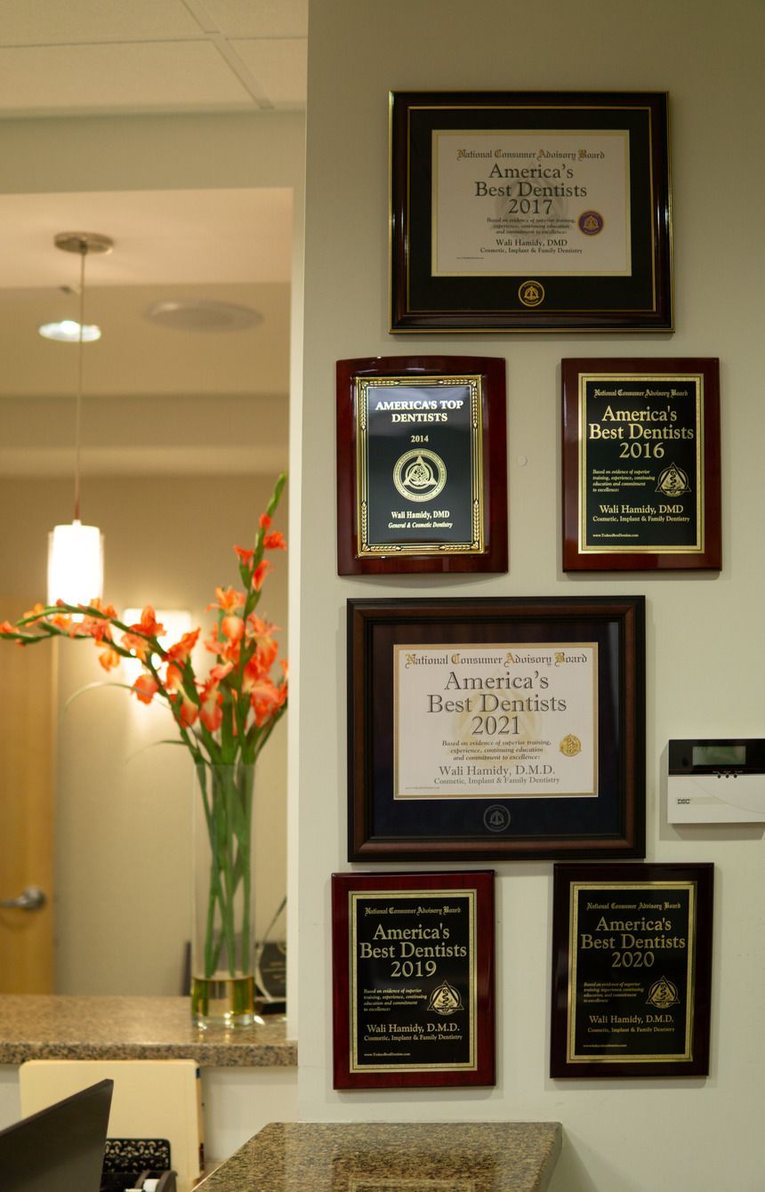 A woman is sitting in a dental chair talking to a dentist.