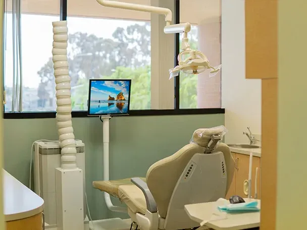 A dental office with a dental chair and a laptop