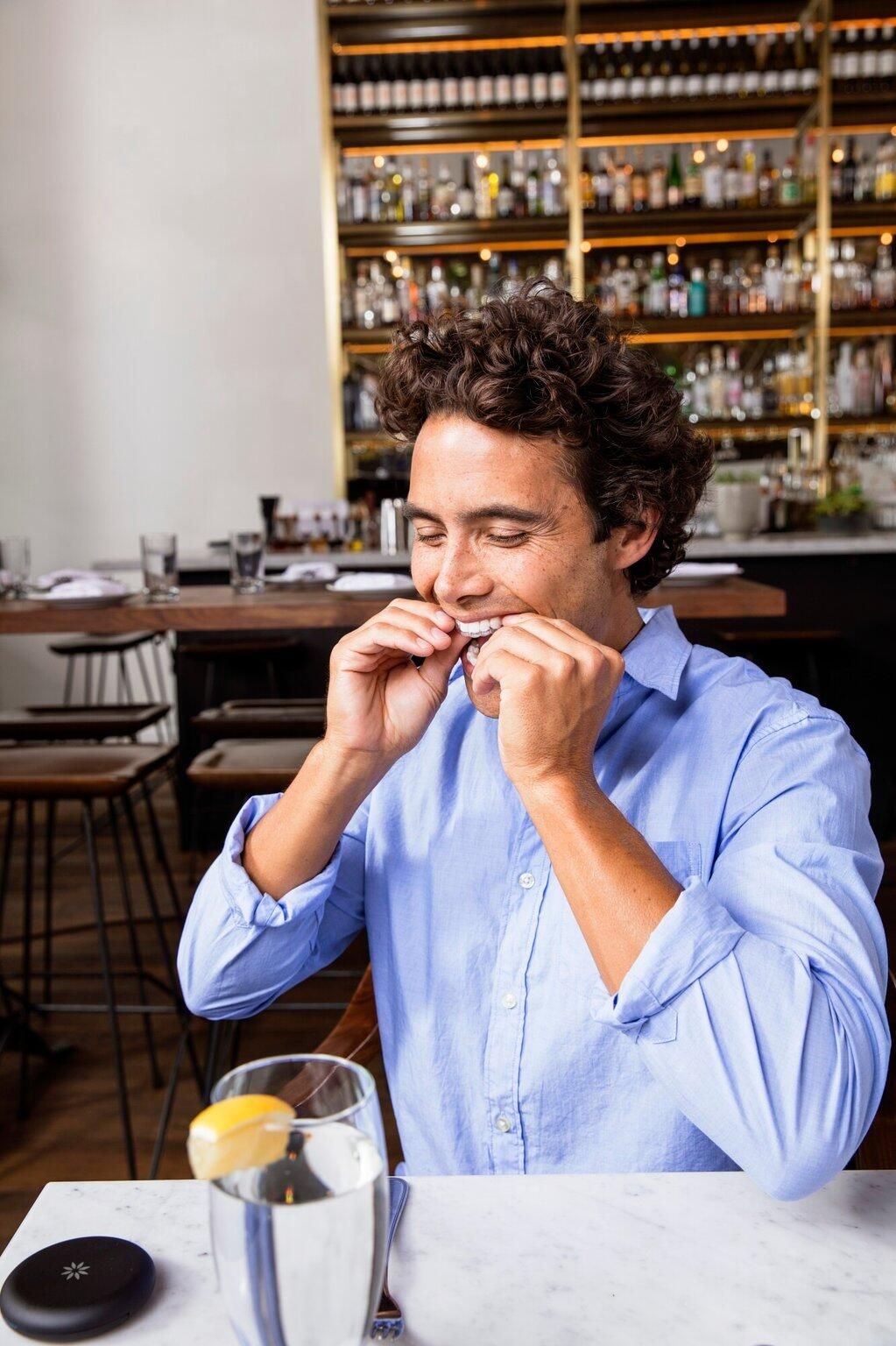 A man is sitting at a table in a restaurant eating something.