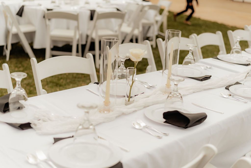 Wedding ceremony on a ranch, couple at altar, guests watch. Mountains in background.