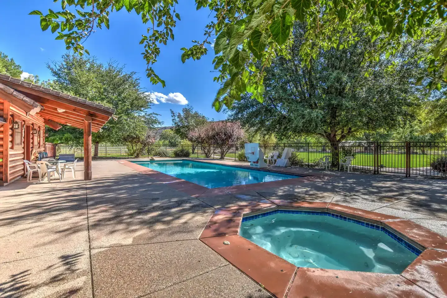 Hot tub on a wooden deck overlooking a field at sunset. Steam rising.