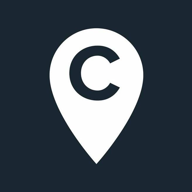 A white pin with the letter c on it on a dark background.