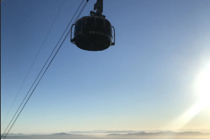 A silhouette of a cable car against a blue sky