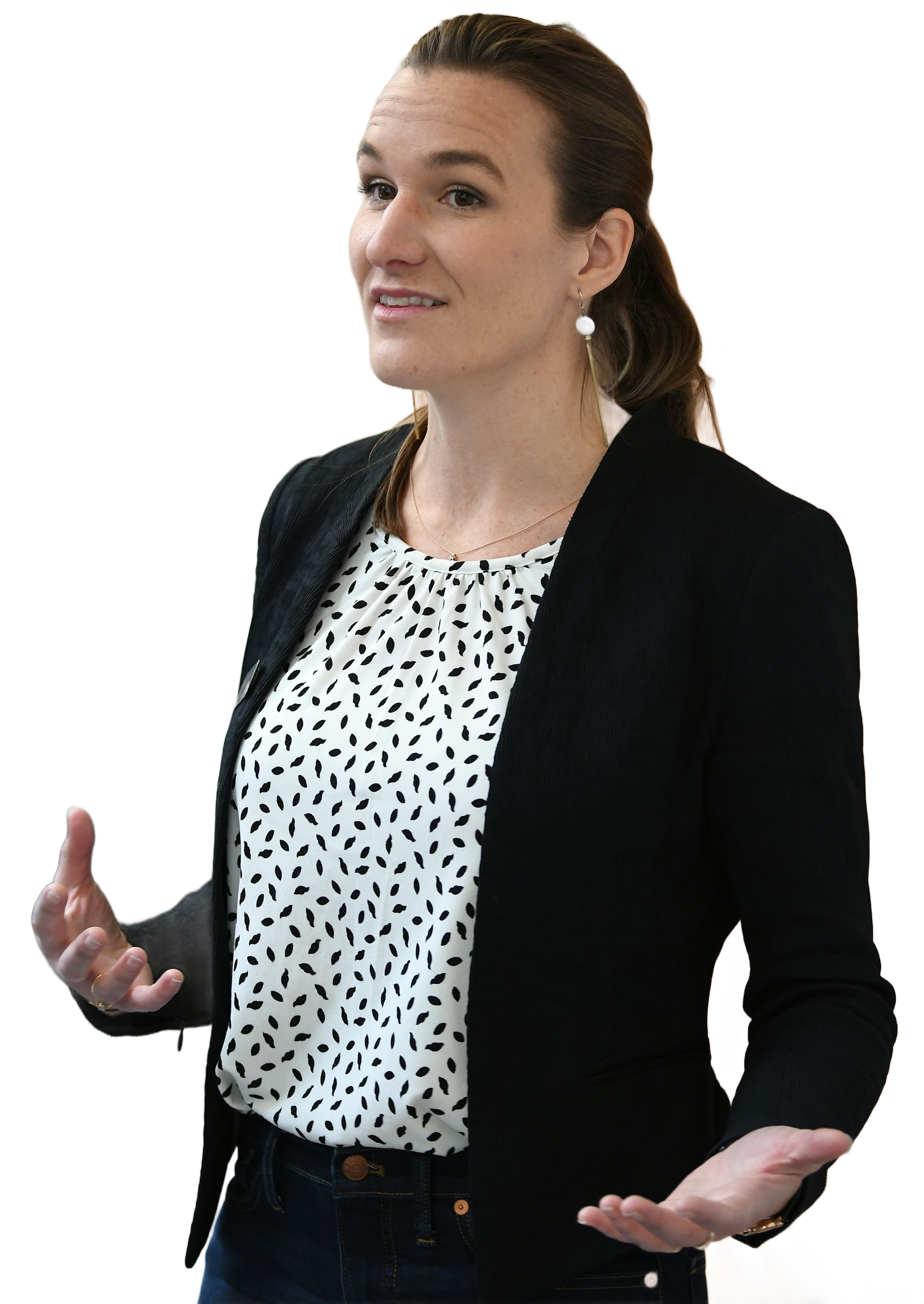 Woman gesturing with hands, wearing a blazer over a patterned blouse.