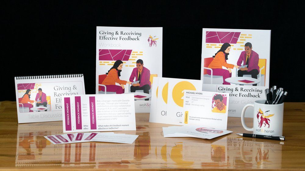 Promotional materials: books, calendar, cards, mug, pens, with an illustration of a feedback session.