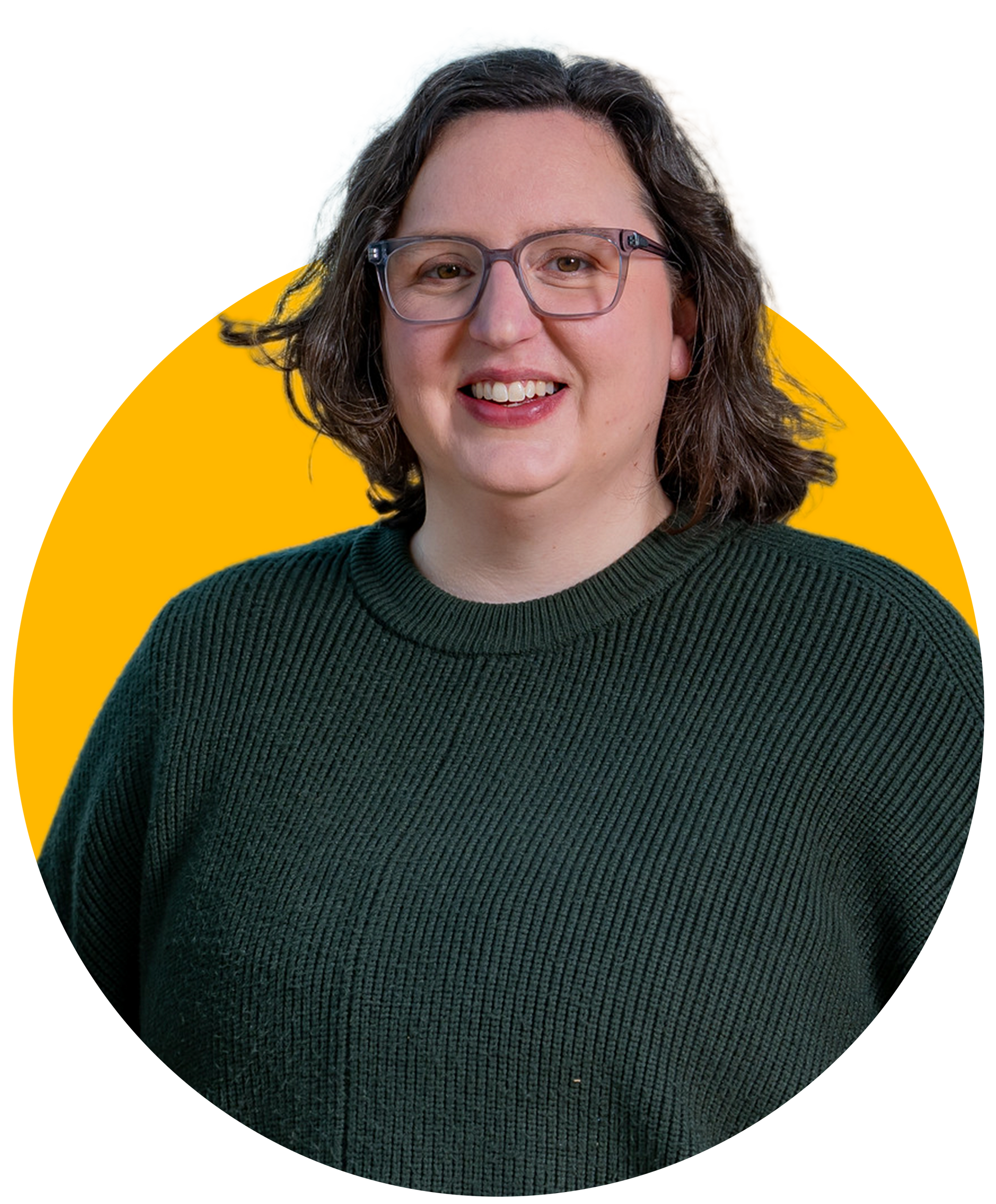 Woman with glasses smiling, wearing a dark green sweater, against a yellow background.