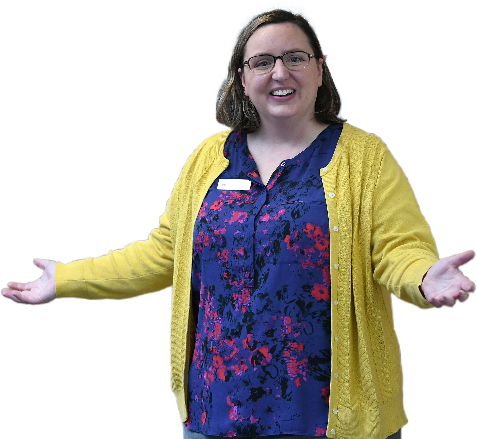 Woman in glasses and yellow sweater, arms outstretched, smiling.