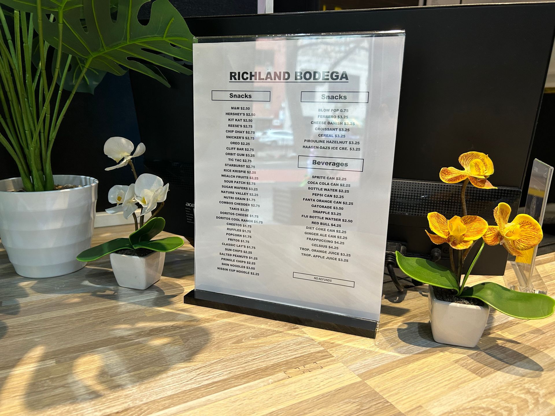 Sign listing yoga classes on a counter with plants.