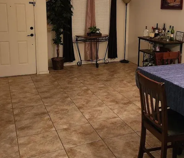 Tile floor in a dining area, with a table, chair, decorative bar, and a door.