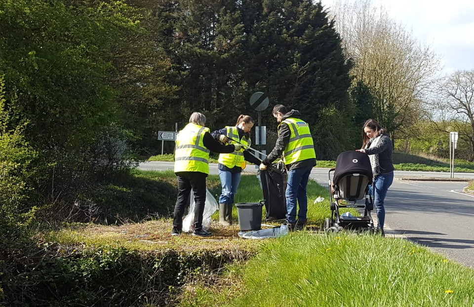 Volunteers in Hi-vis vests clearing litter from the roadside