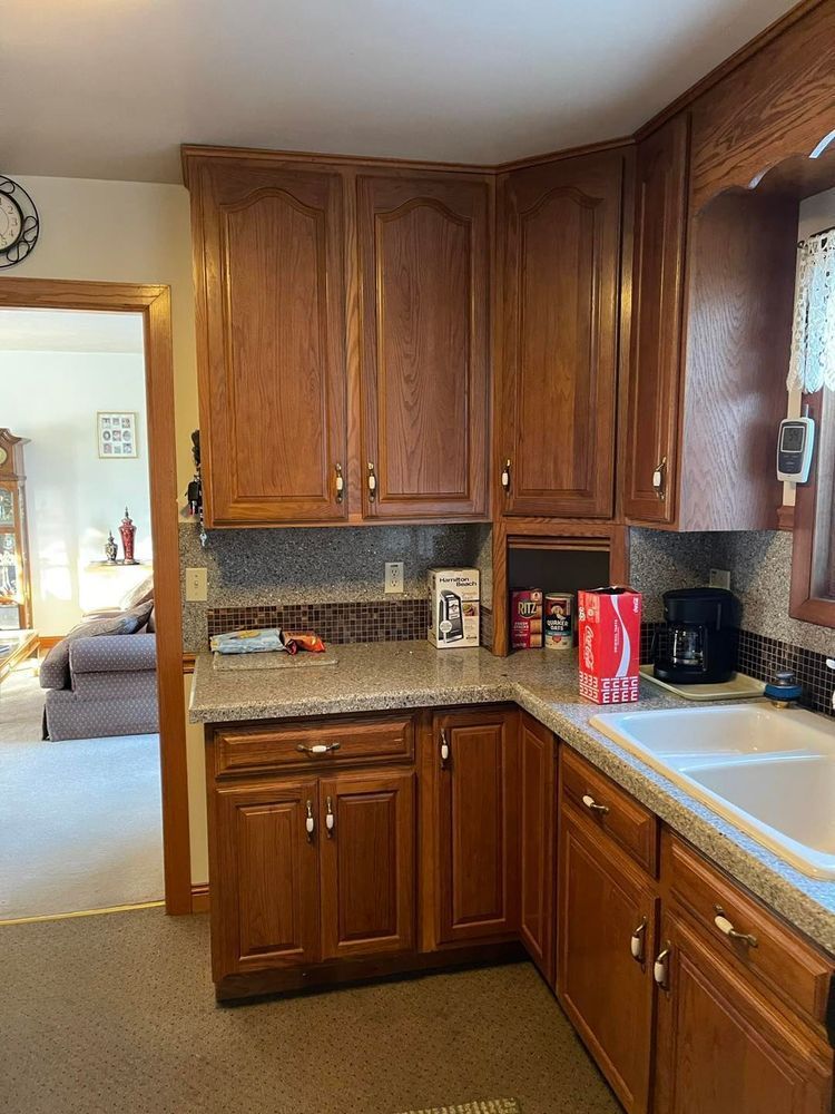 A kitchen with wooden cabinets , granite counter tops , and a sink.