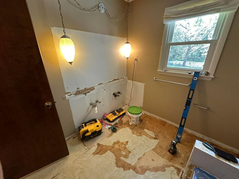 A bathroom is being remodeled with a toilet and a window.