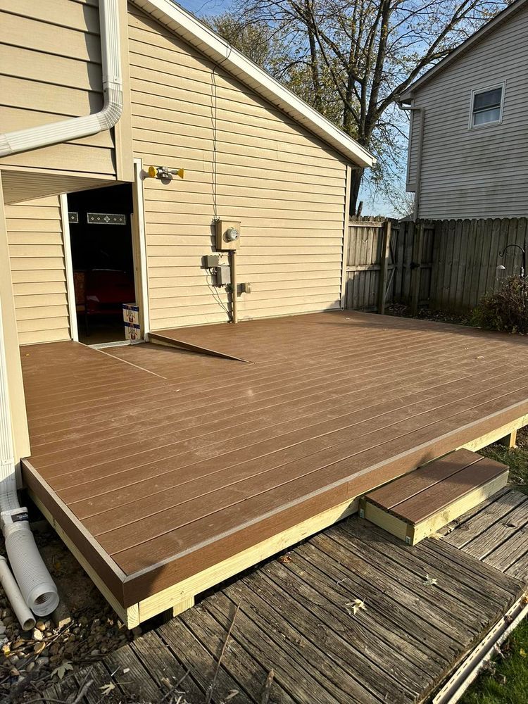 A wooden deck is sitting in front of a house.