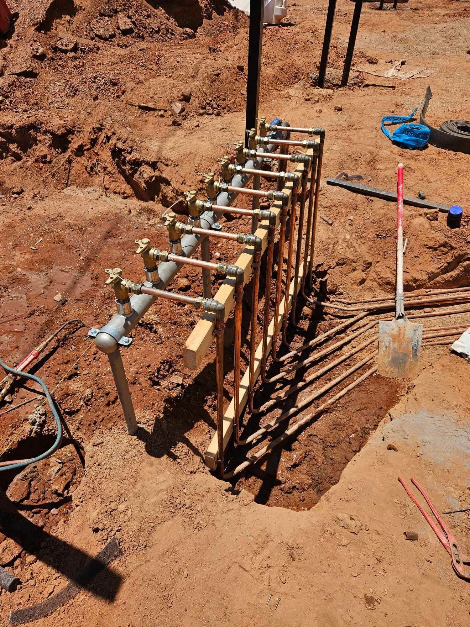 A wooden structure is sitting in the dirt next to a shovel.