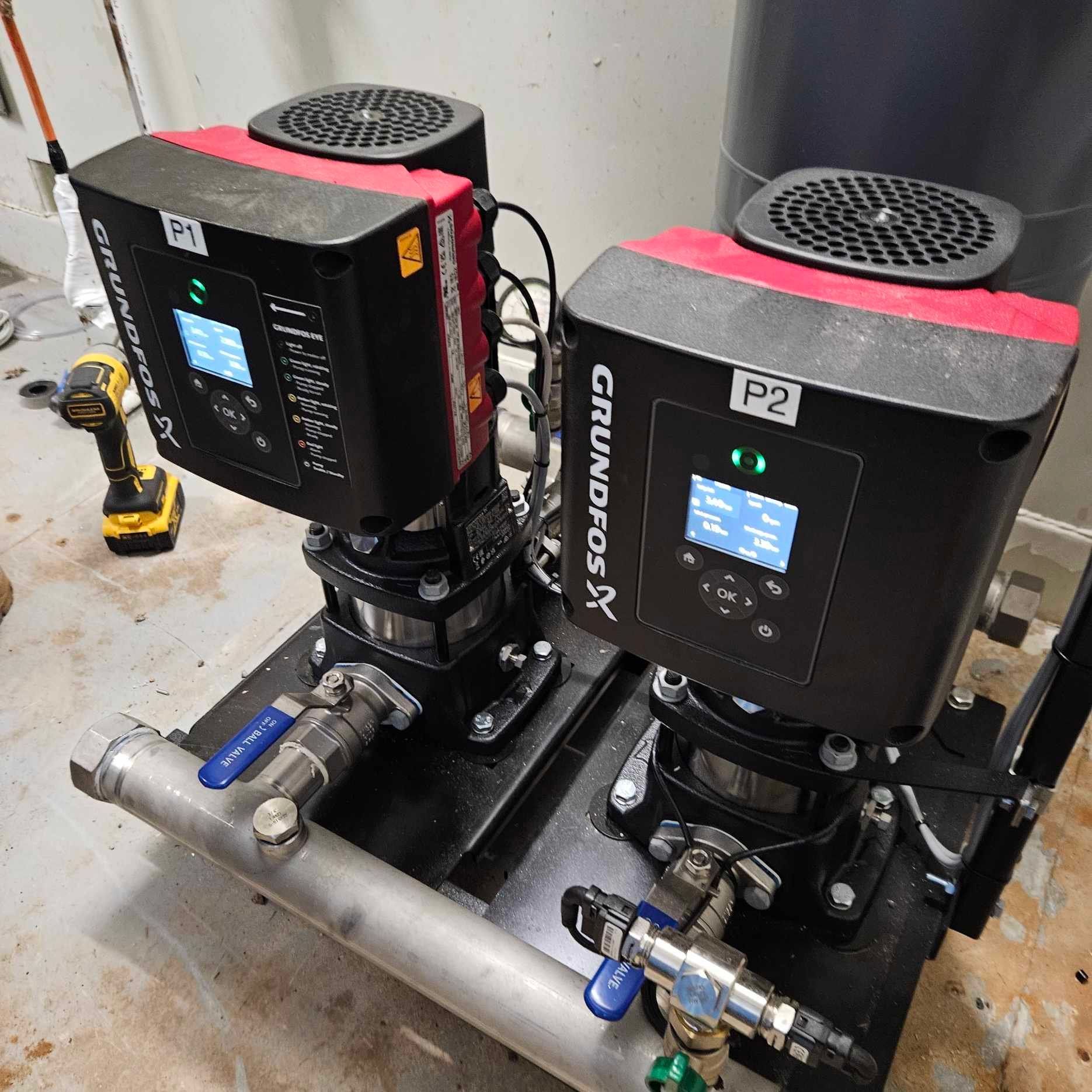 Two grundfos pumps are sitting next to each other on a table.