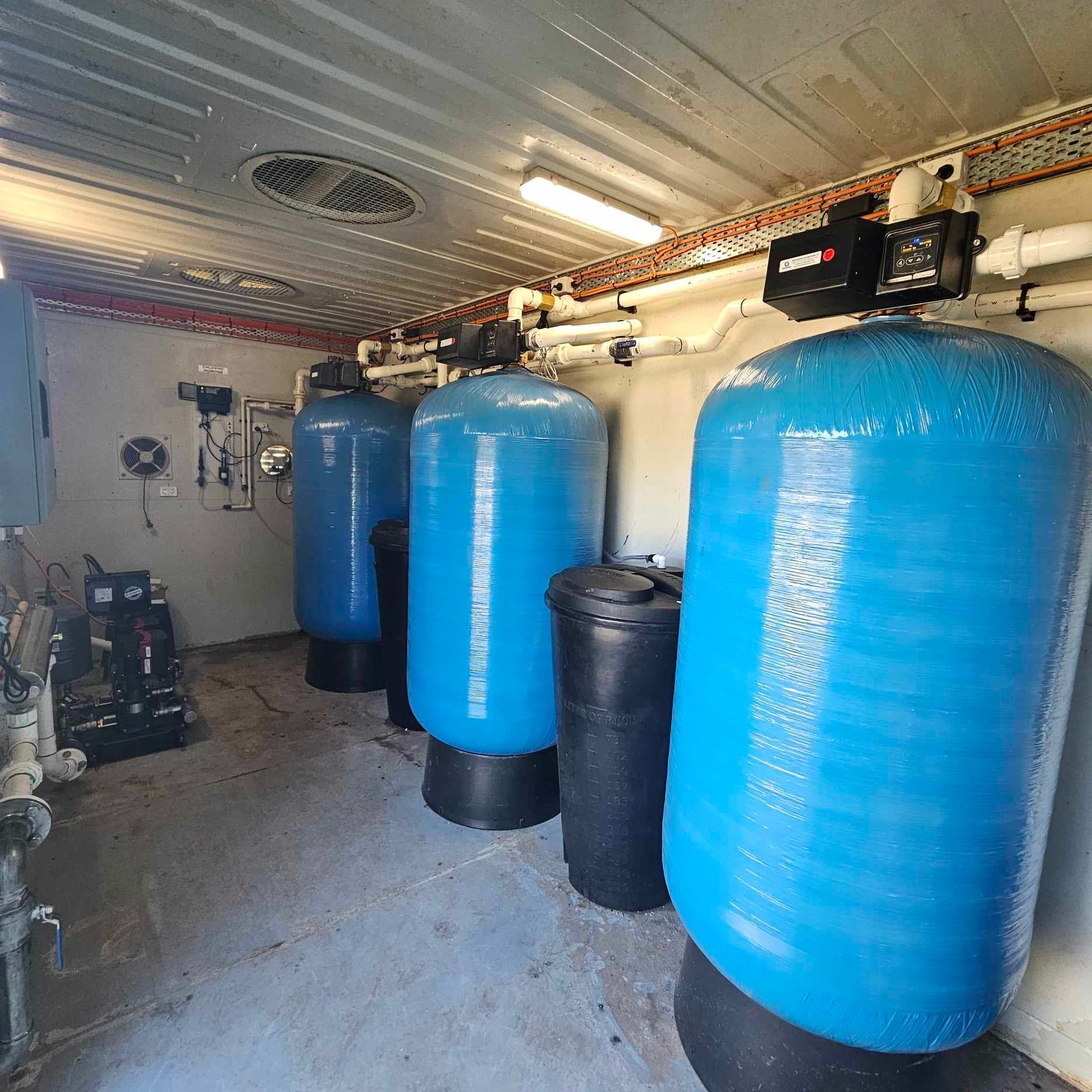 A room filled with lots of blue water tanks.