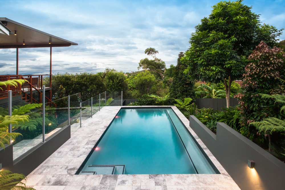 Modern Hotel With A Pool Under The Bright Blue Sky With White Clouds Beautifully Spread — Pool Maintenance in Cannonvale, QLD