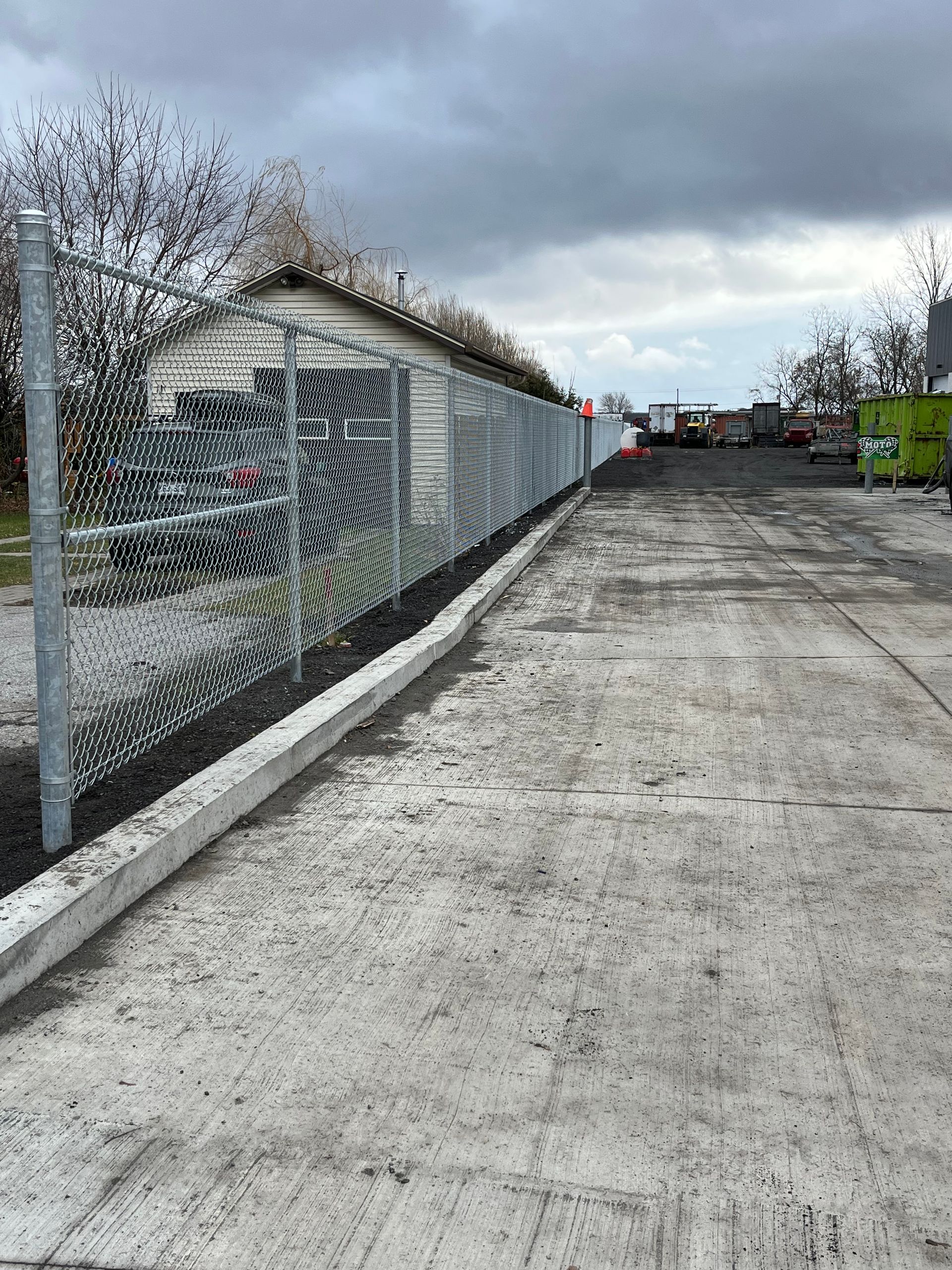 Il y a une clôture grillagée le long du côté de la route.