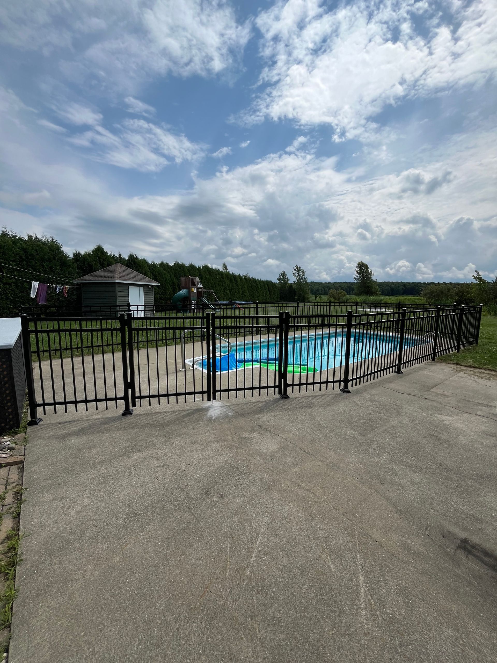 Une clôture avec des graffitis entoure une piscine.