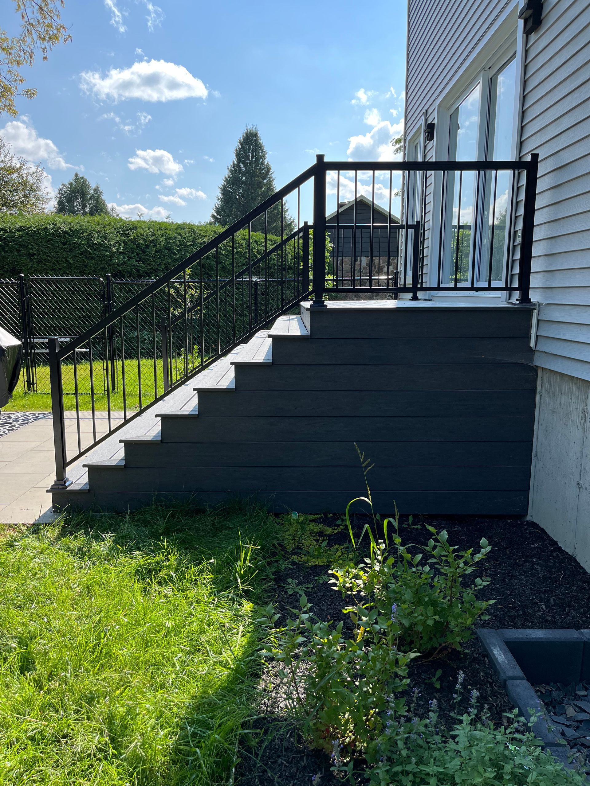 Il y a une terrasse avec des escaliers qui y mènent.