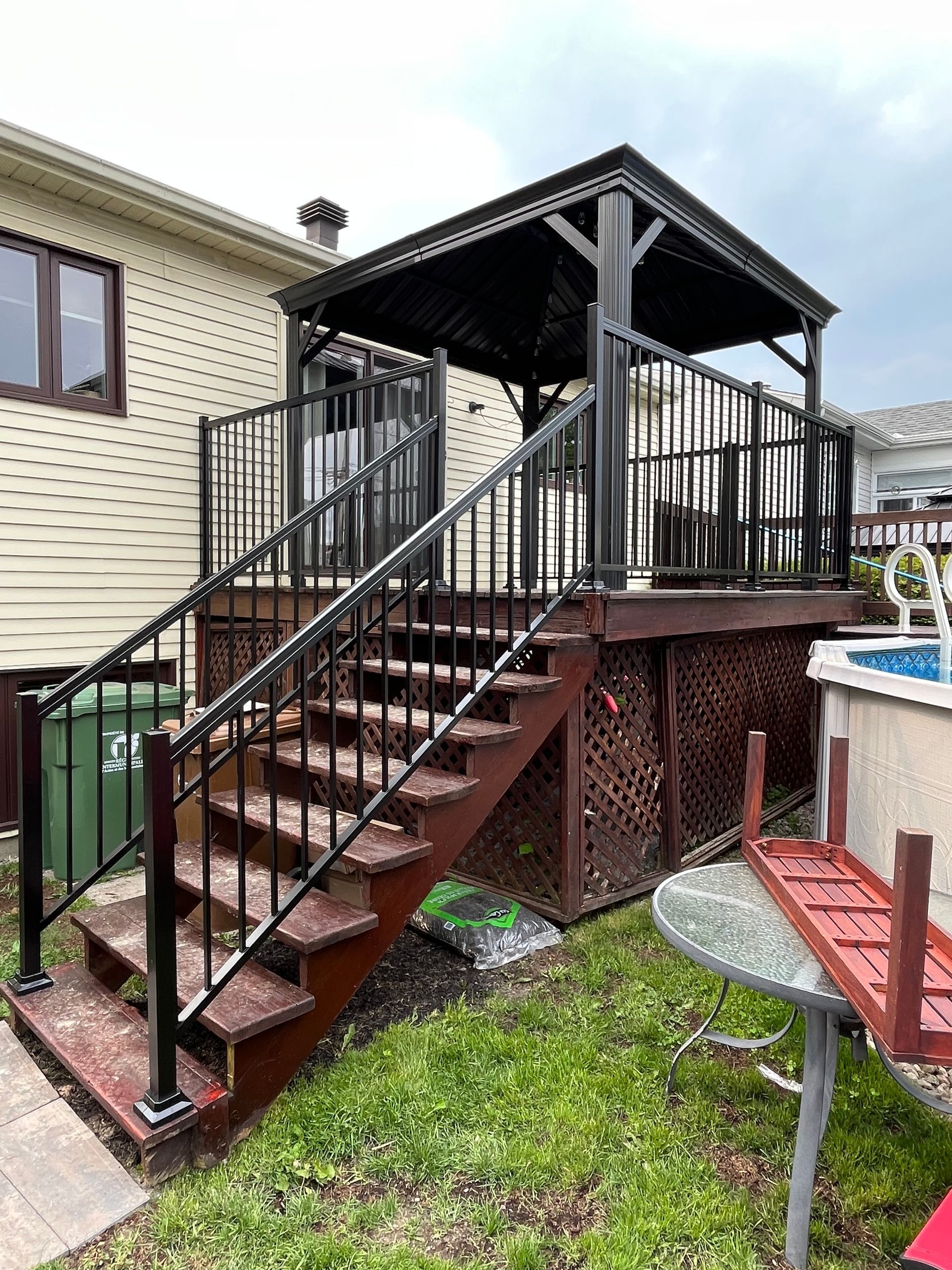 Une terrasse avec des escaliers qui y mènent à côté d'une piscine.