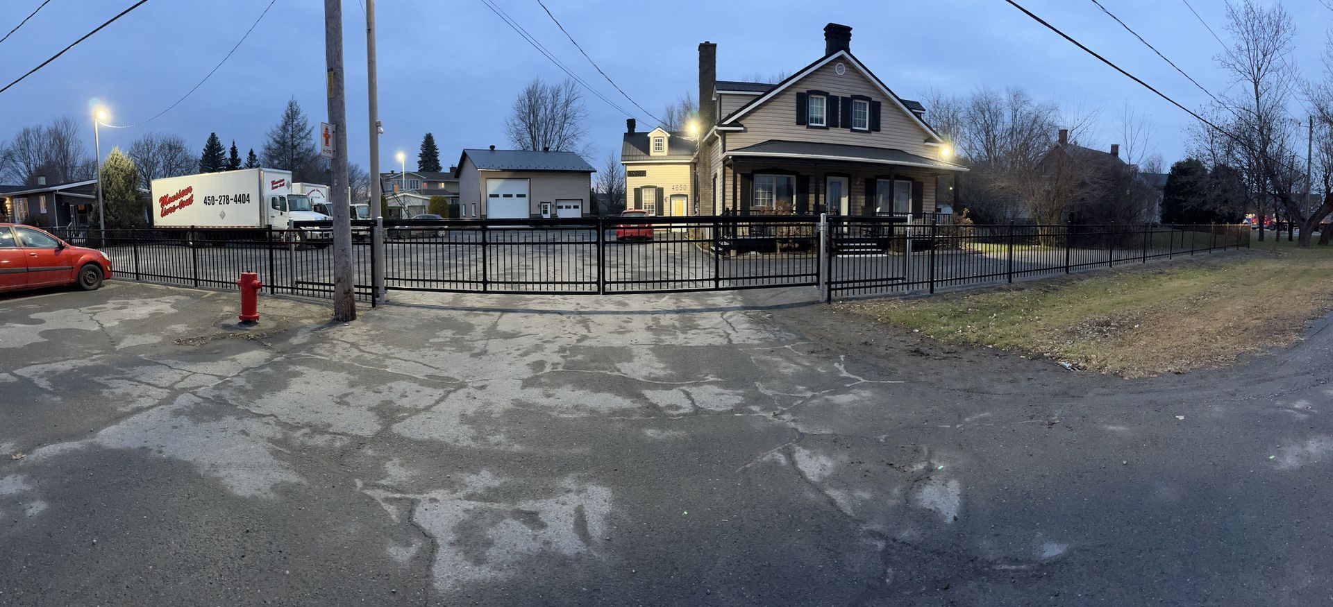 Une maison est située sur le bord de la route à côté d'une bouche d'incendie.