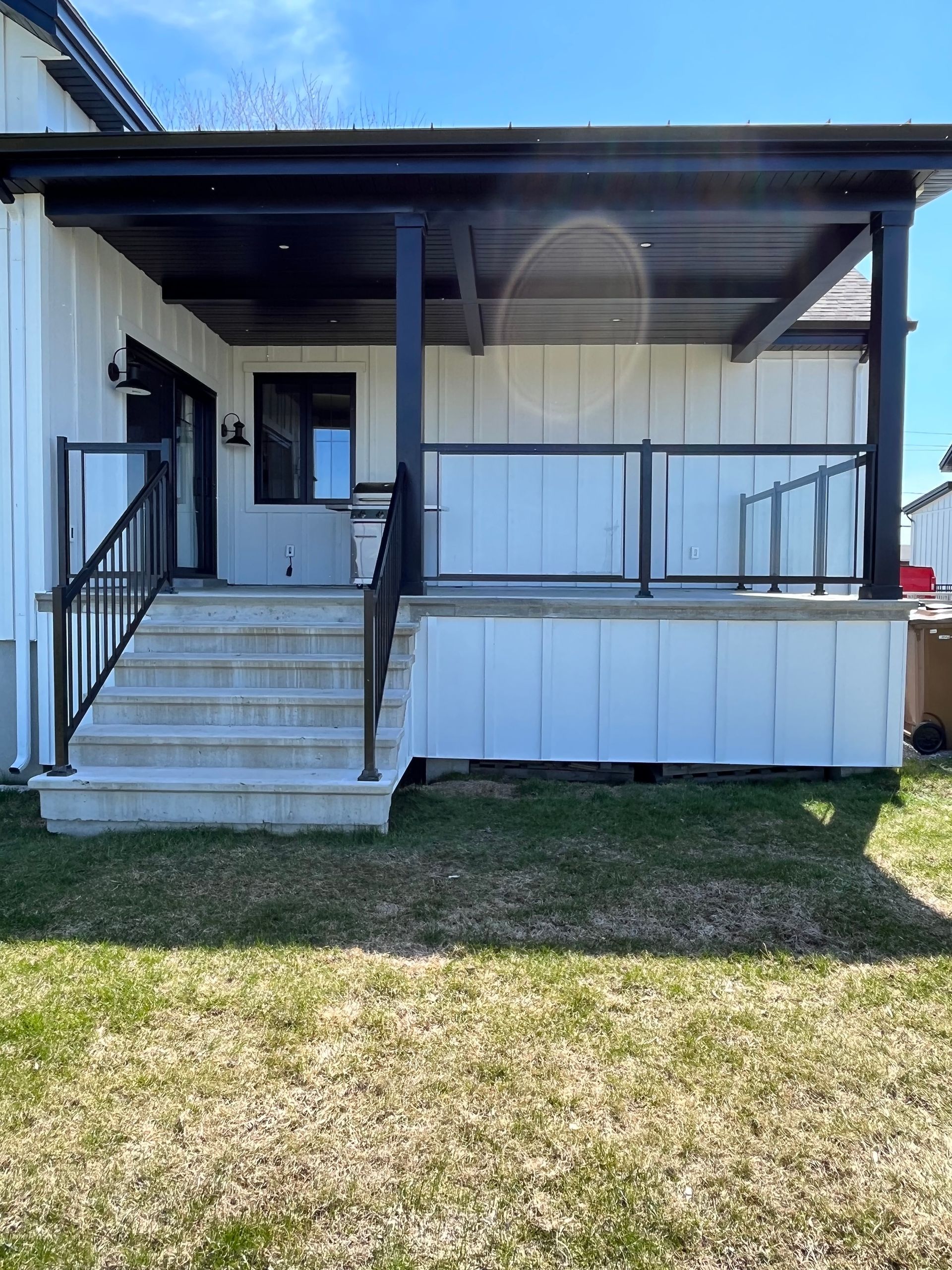 L'arrière d'une maison avec un porche et des escaliers.