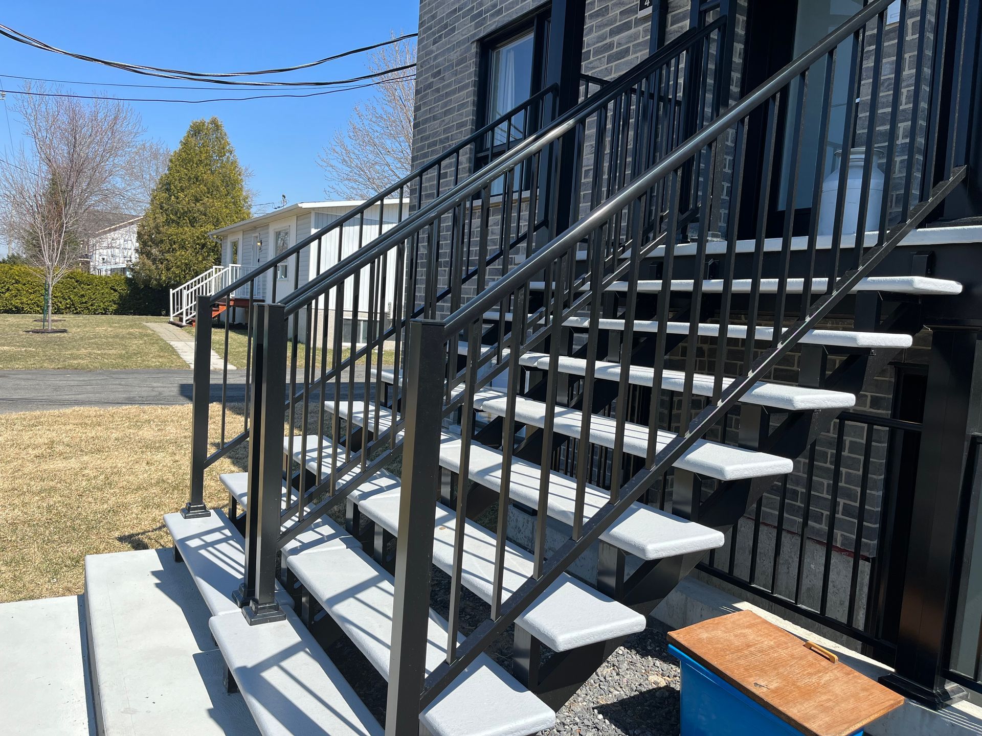 Un ensemble d'escaliers menant à un bâtiment en briques avec une balustrade en métal.