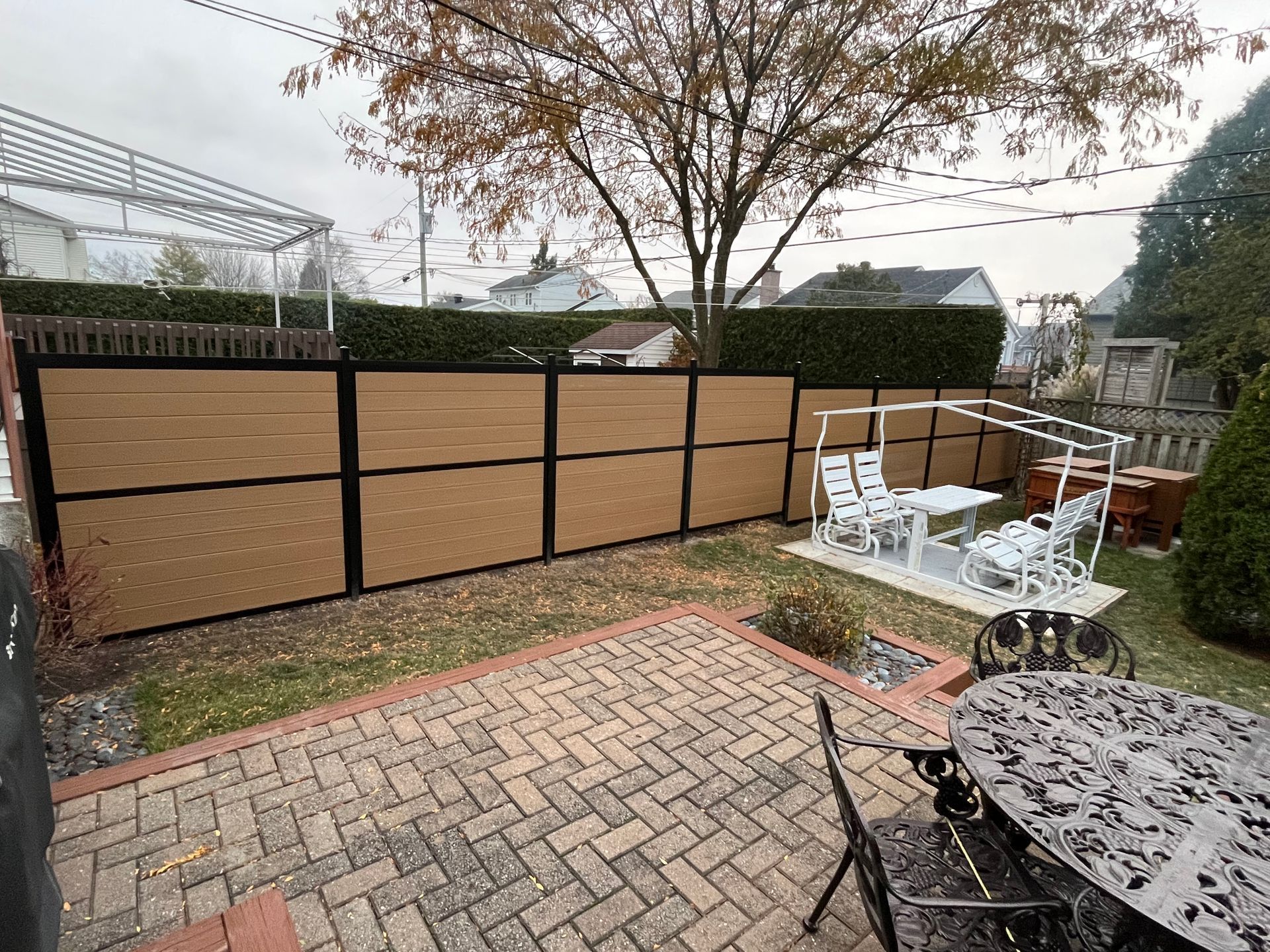 Une cour arrière avec une clôture en bois et un patio avec une table et des chaises.
