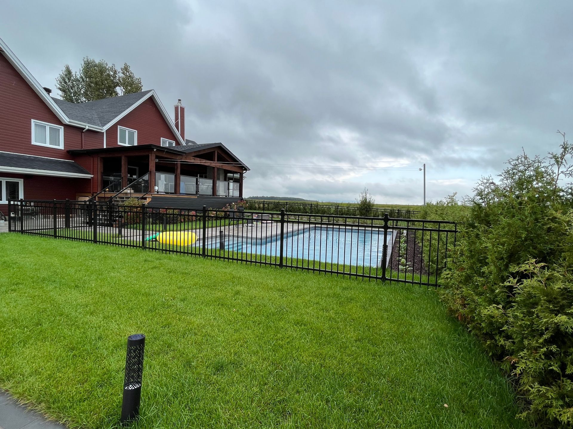 Une grande maison rouge avec une piscine devant.