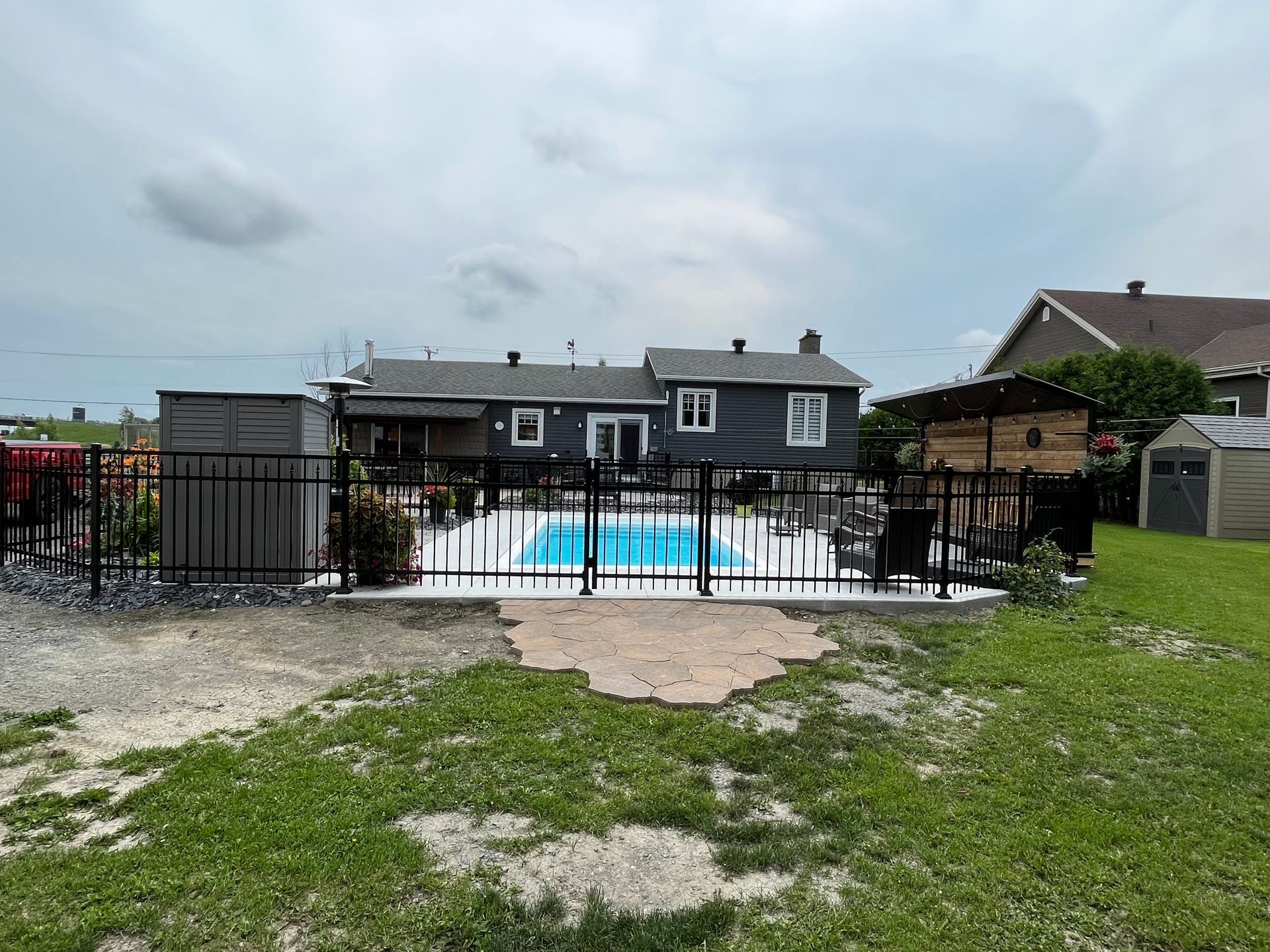 Une grande maison avec une piscine dans l'arrière-cour derrière une clôture.