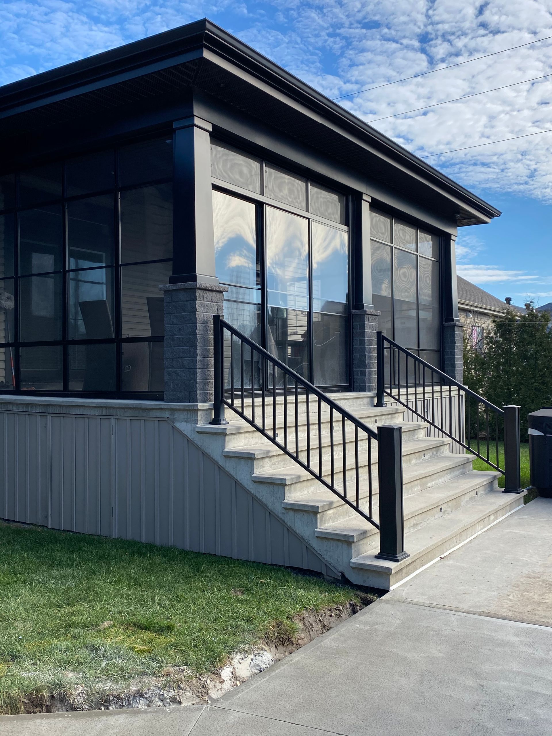 Une maison noire avec des escaliers qui y mènent