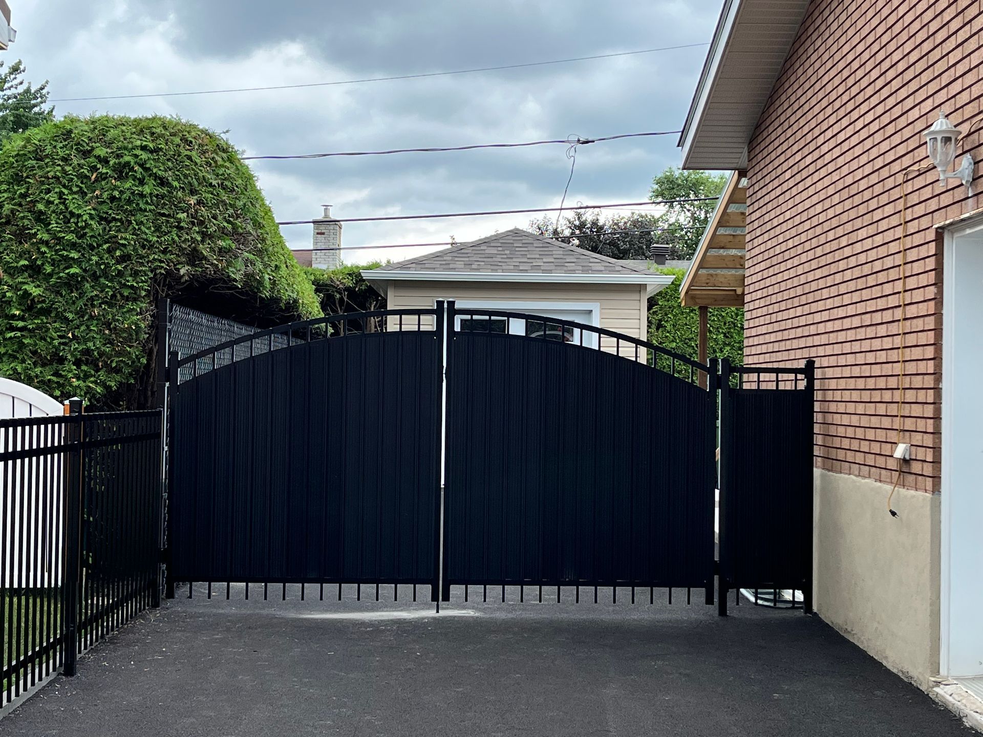 Une porte noire se trouve devant une maison en briques.
