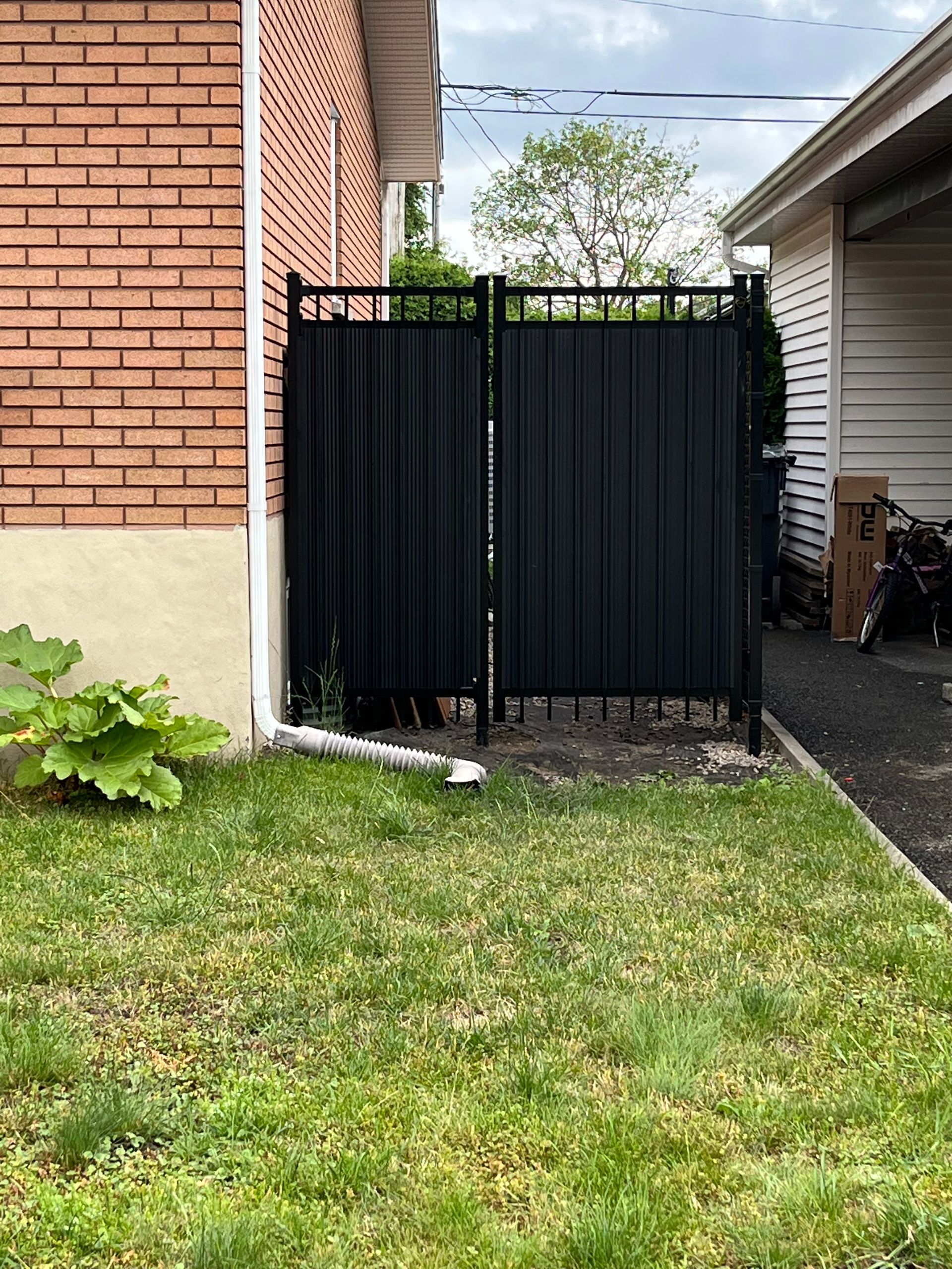 Il y a une clôture noire dans l'arrière-cour d'une maison.