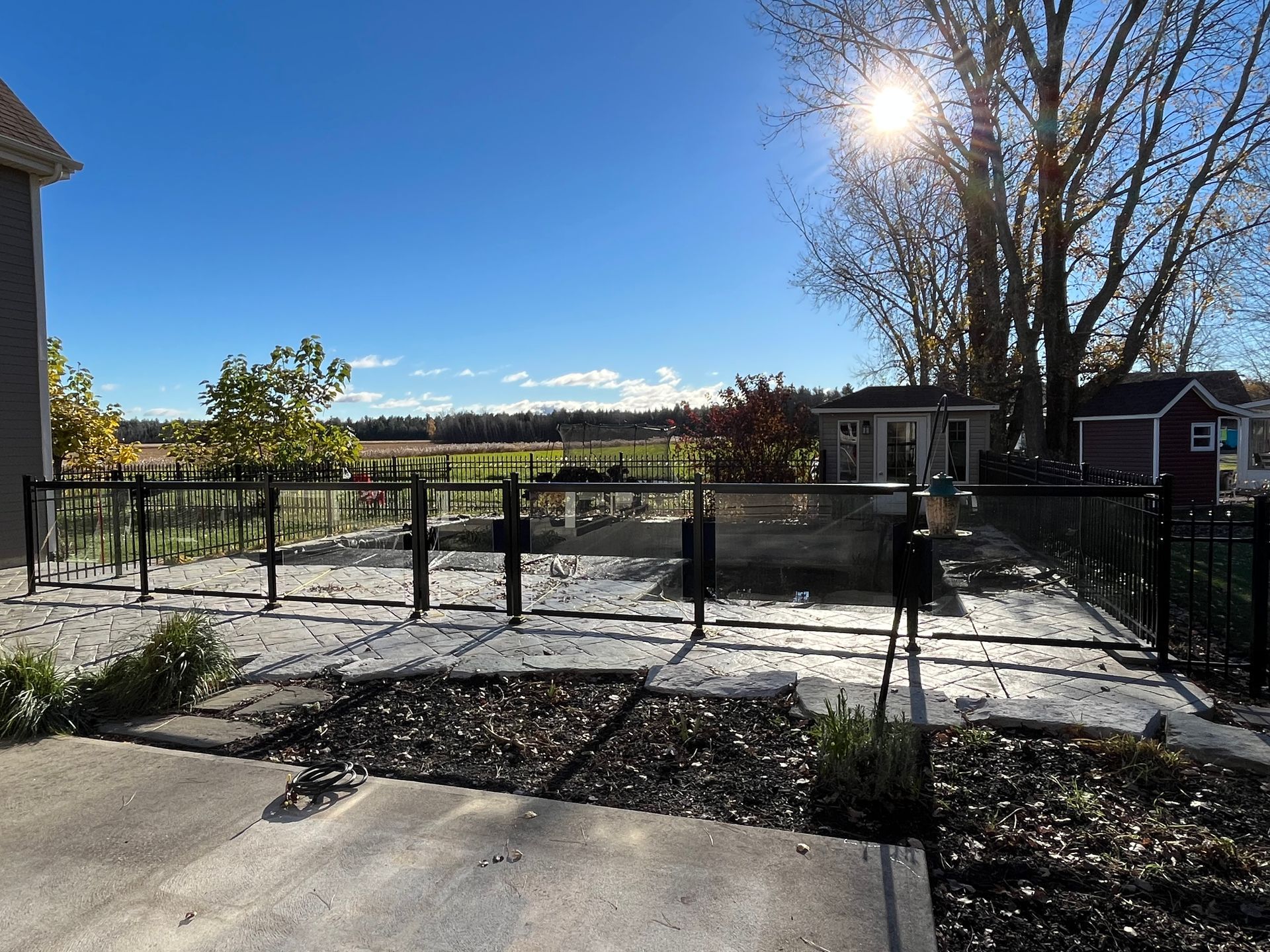 Une clôture avec vue sur un champ et une maison en arrière-plan