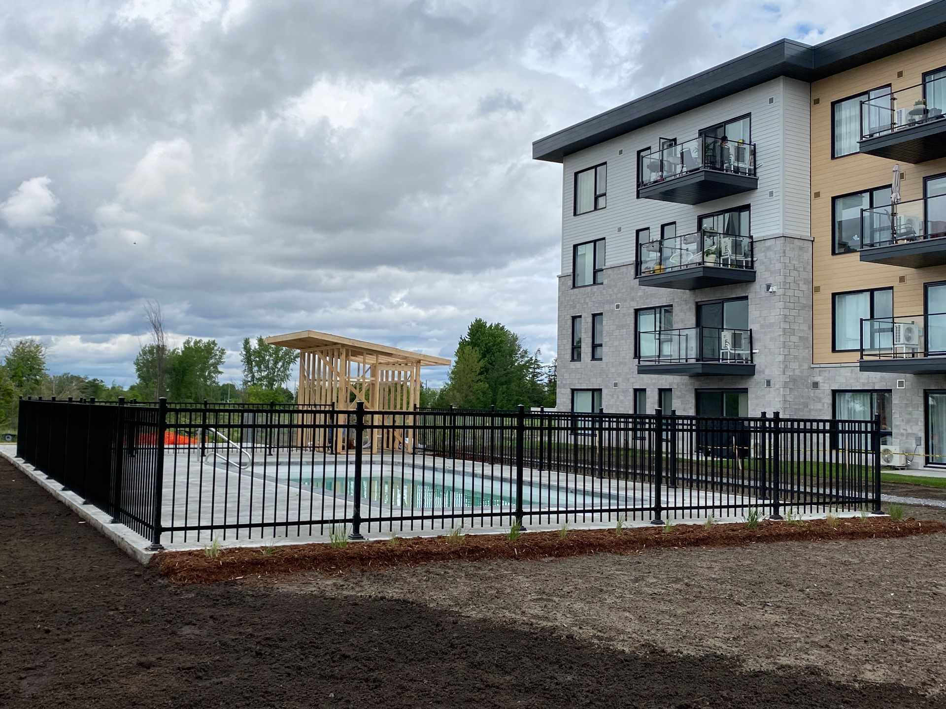 Un grand immeuble d'appartements avec une piscine devant.