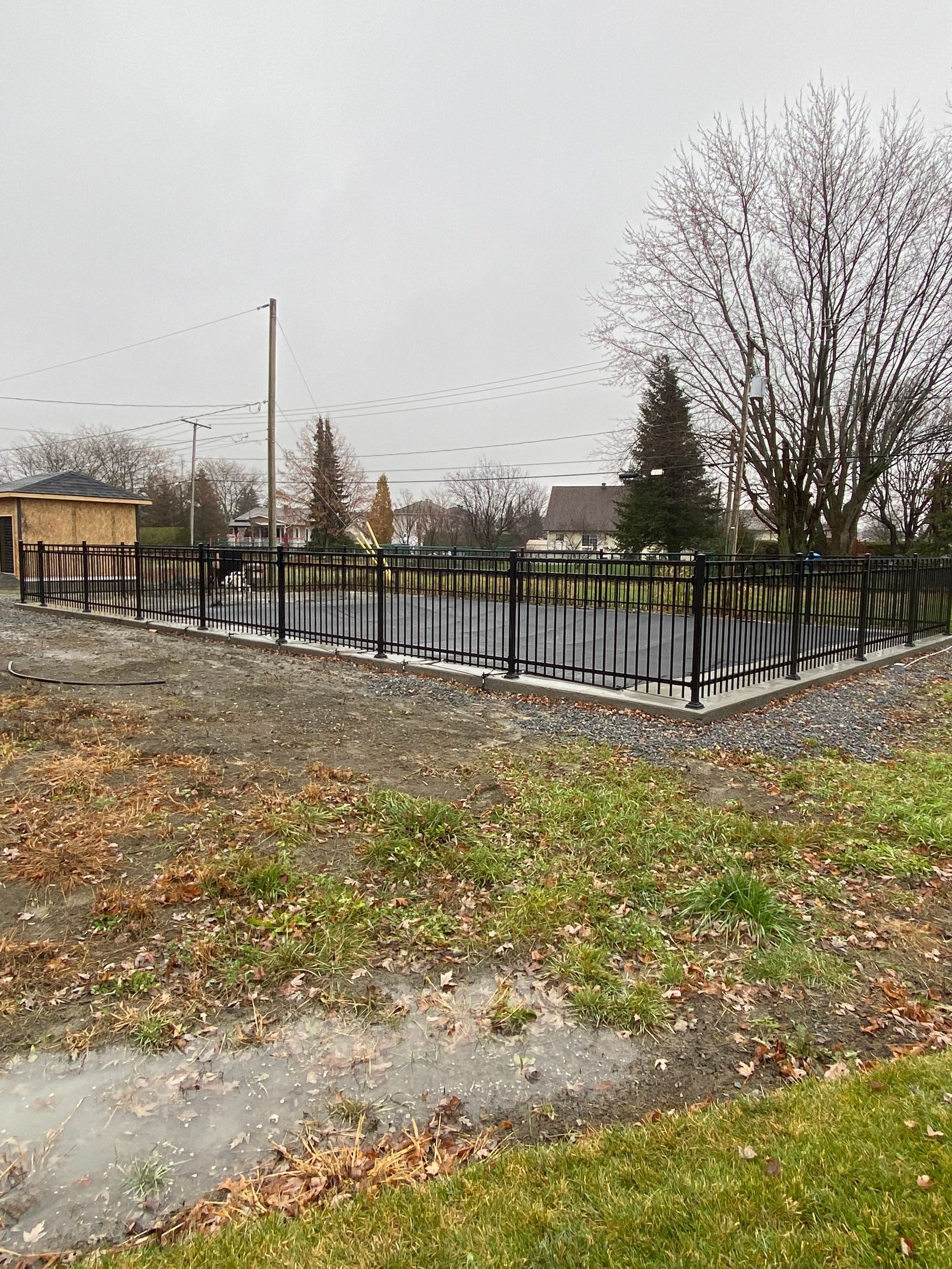 Il y a une clôture au milieu d'un champ herbeux.