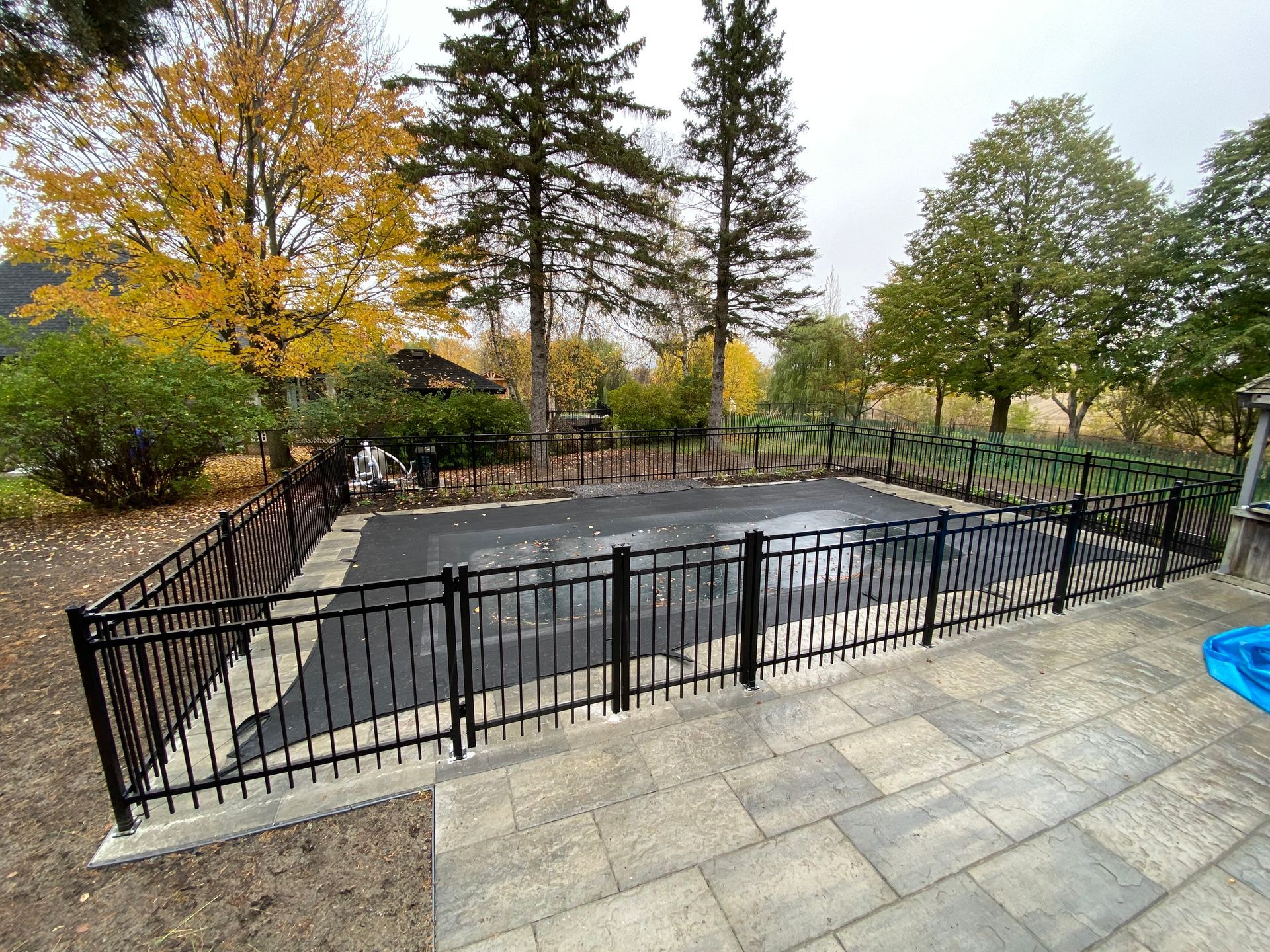 Une grande piscine entourée d'une clôture métallique.