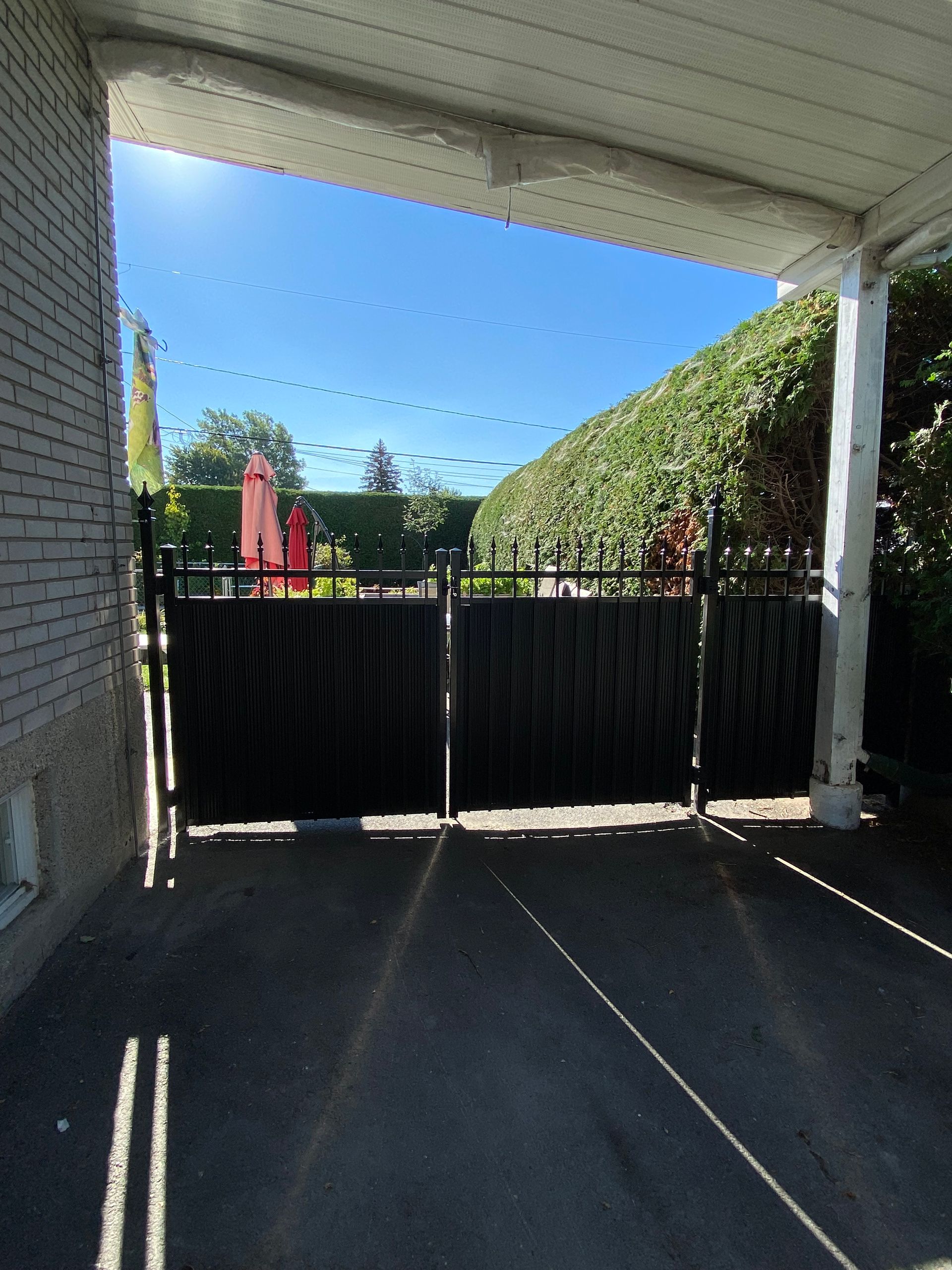 Une porte noire est entourée d'un mur de briques blanches