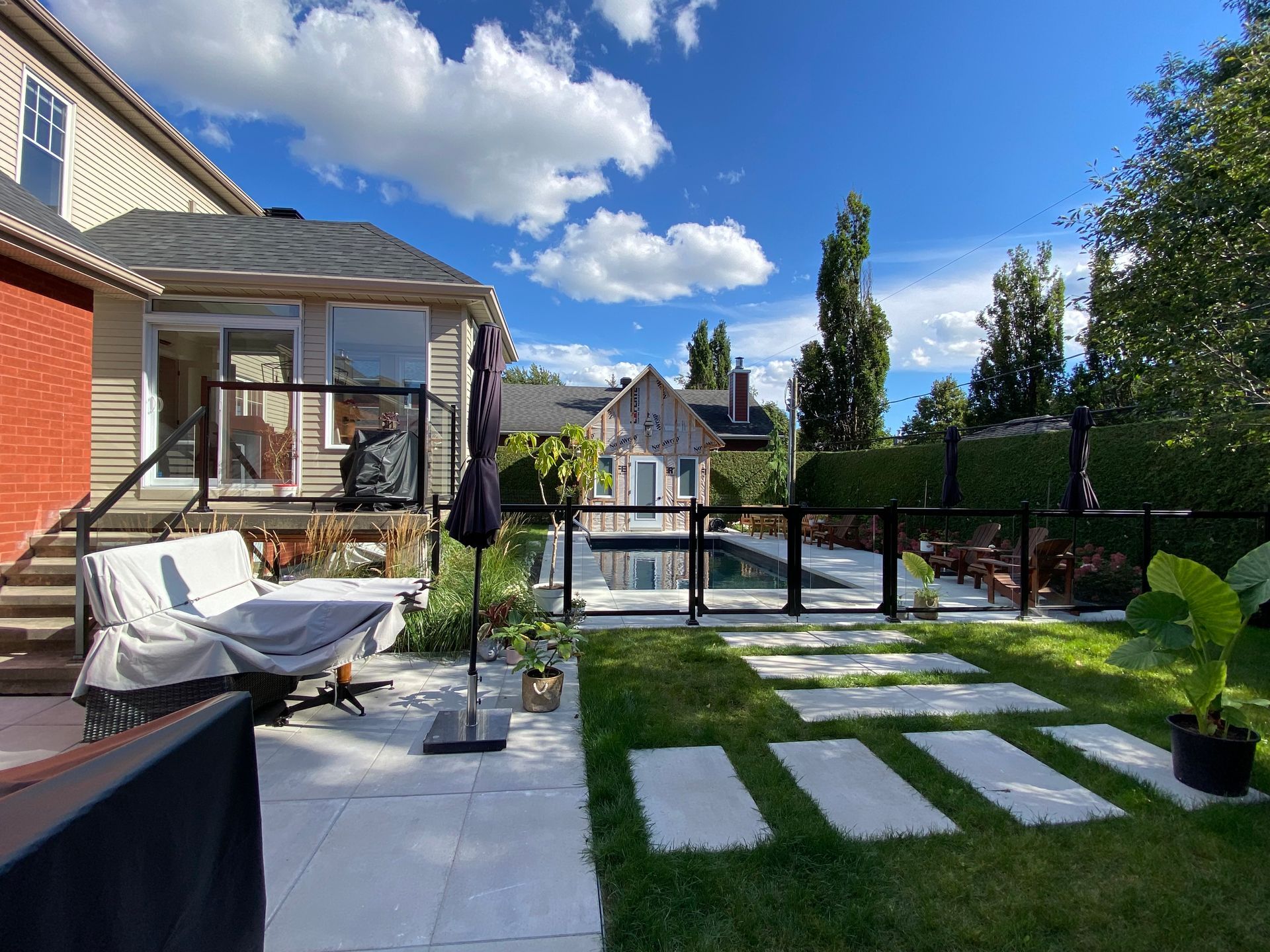 L'arrière-cour d'une maison avec un patio et une piscine.