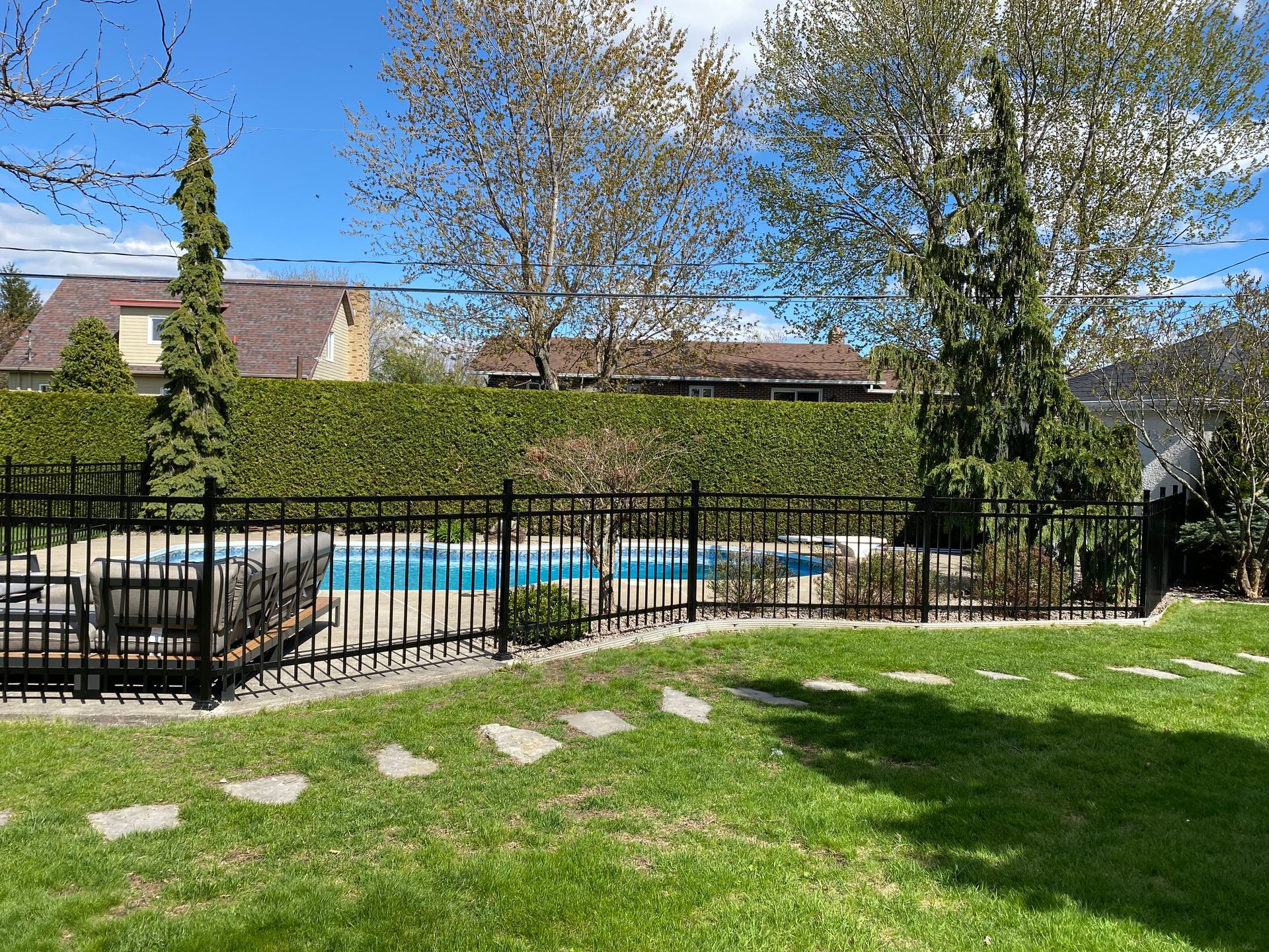 Il y a une piscine dans l'arrière-cour derrière une clôture.