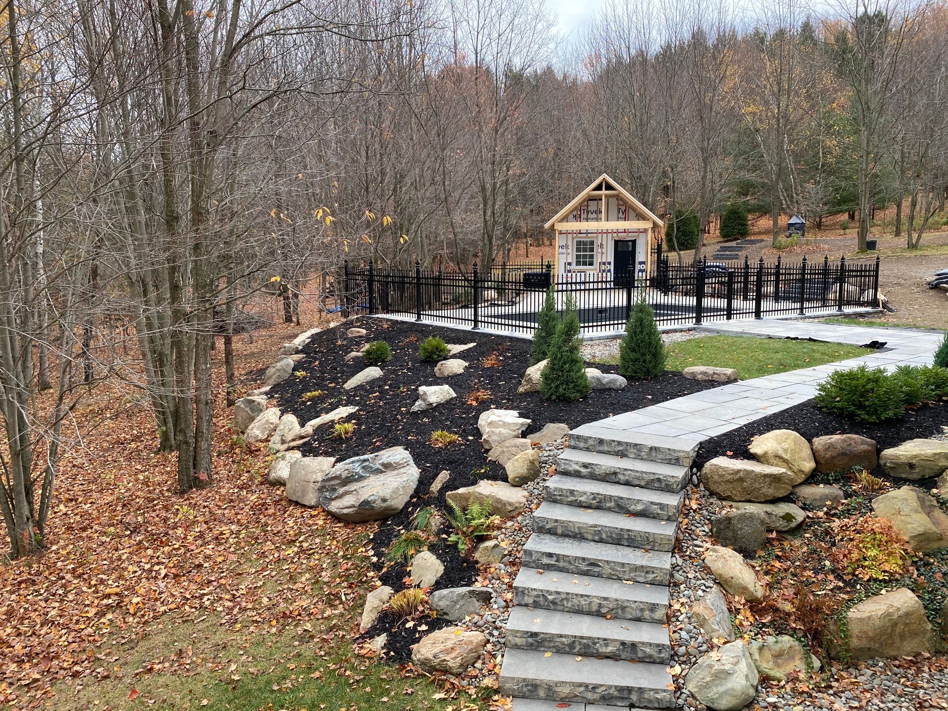 Un chemin de pierre menant à une maison au milieu d'une forêt.
