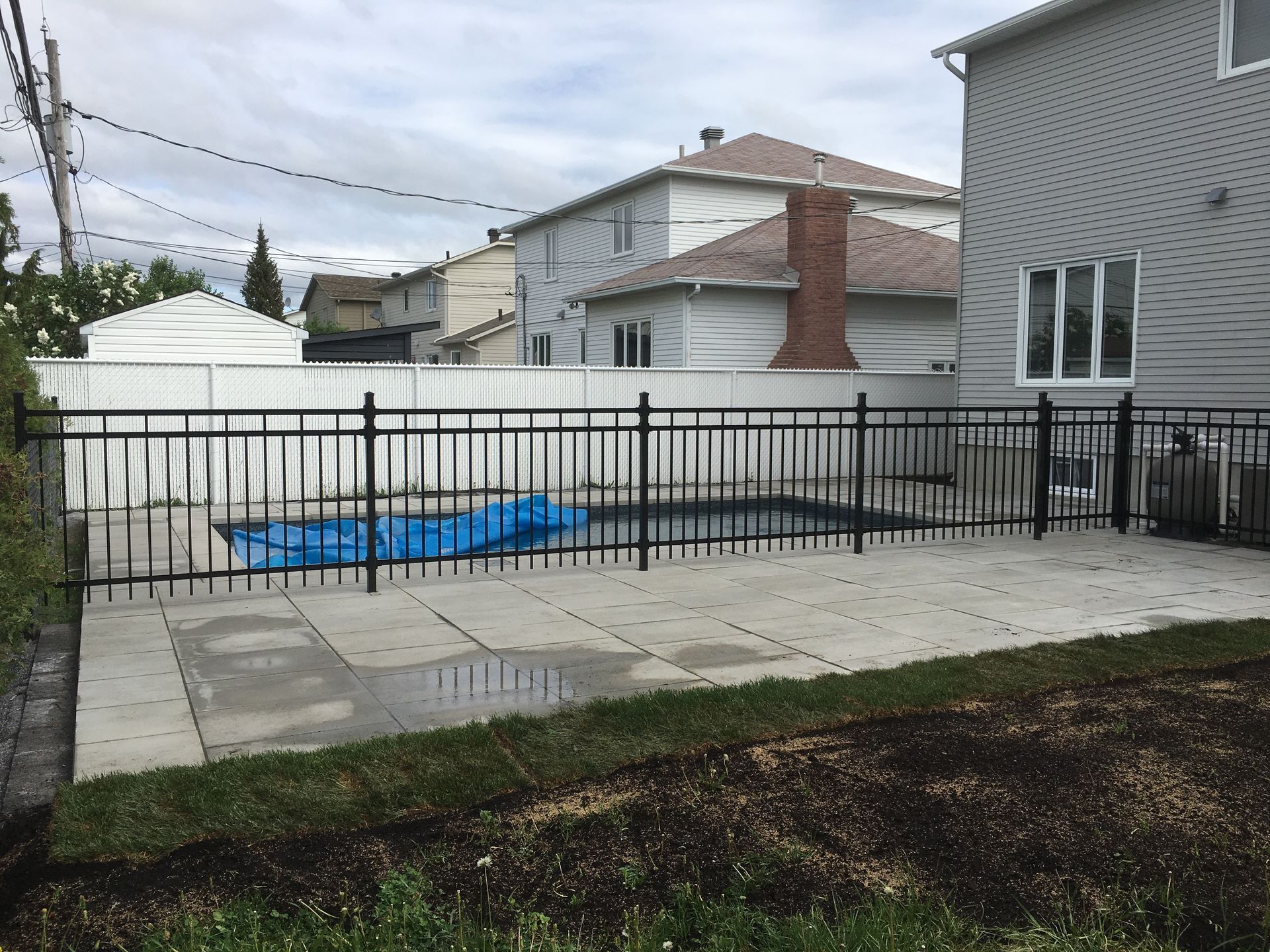 Une cour arrière avec une piscine et une clôture autour