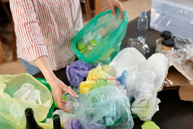 Person sorting plastic recycling into bags.