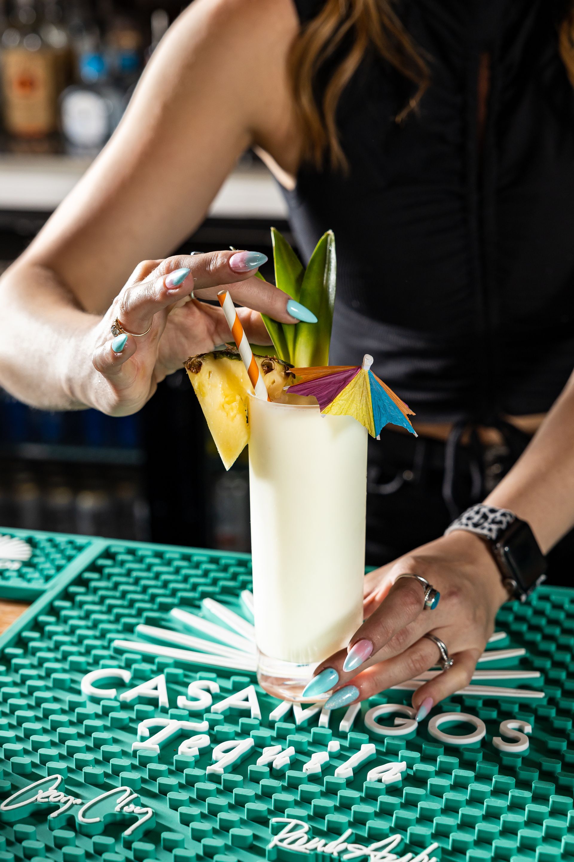 A woman is making a cocktail at con safos in denver