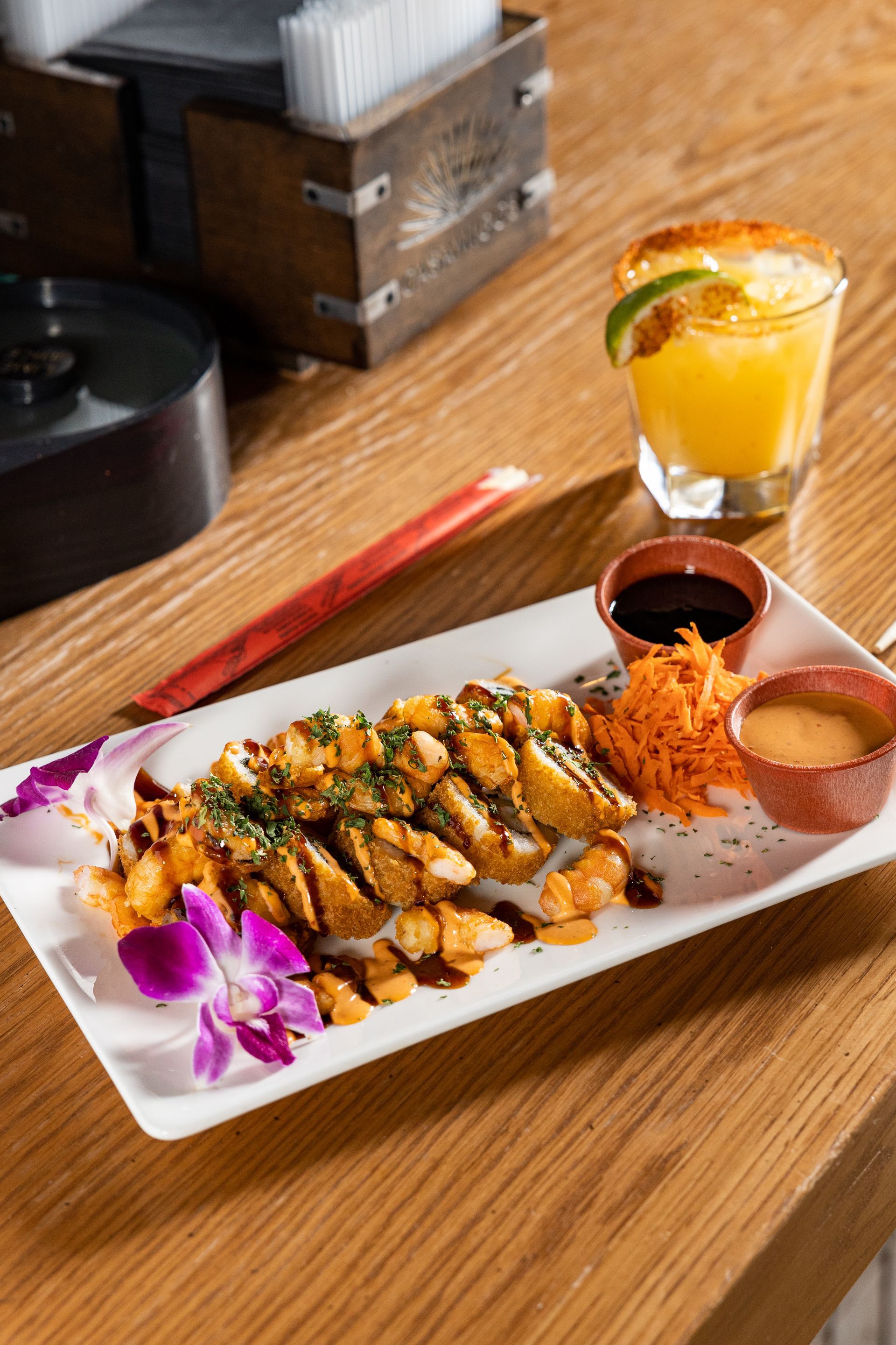A plate of food and a drink on a wooden table at con safos in downtown denver