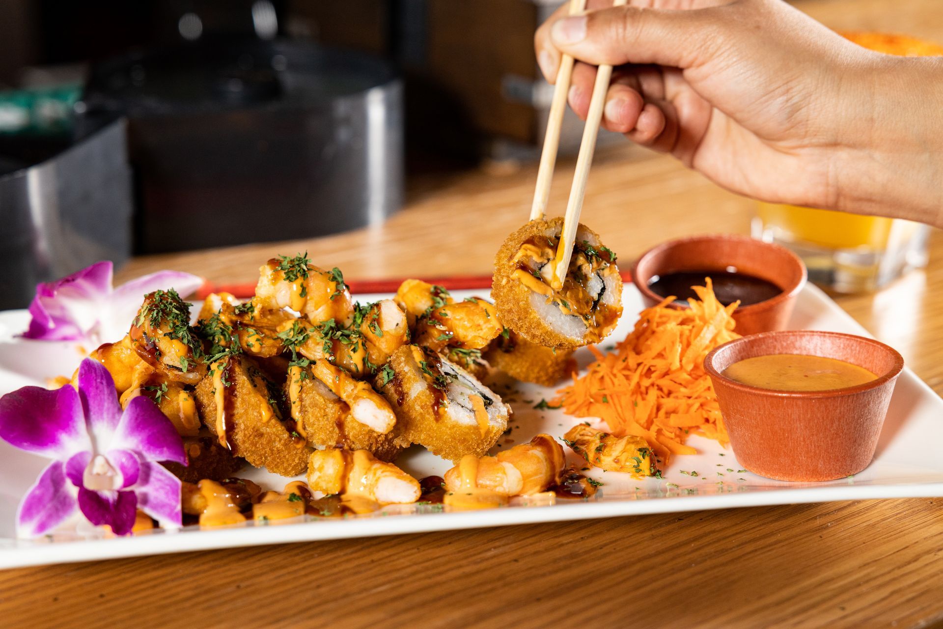 A person is eating sushi with chopsticks from a plate at con safos in downtown denver colorado